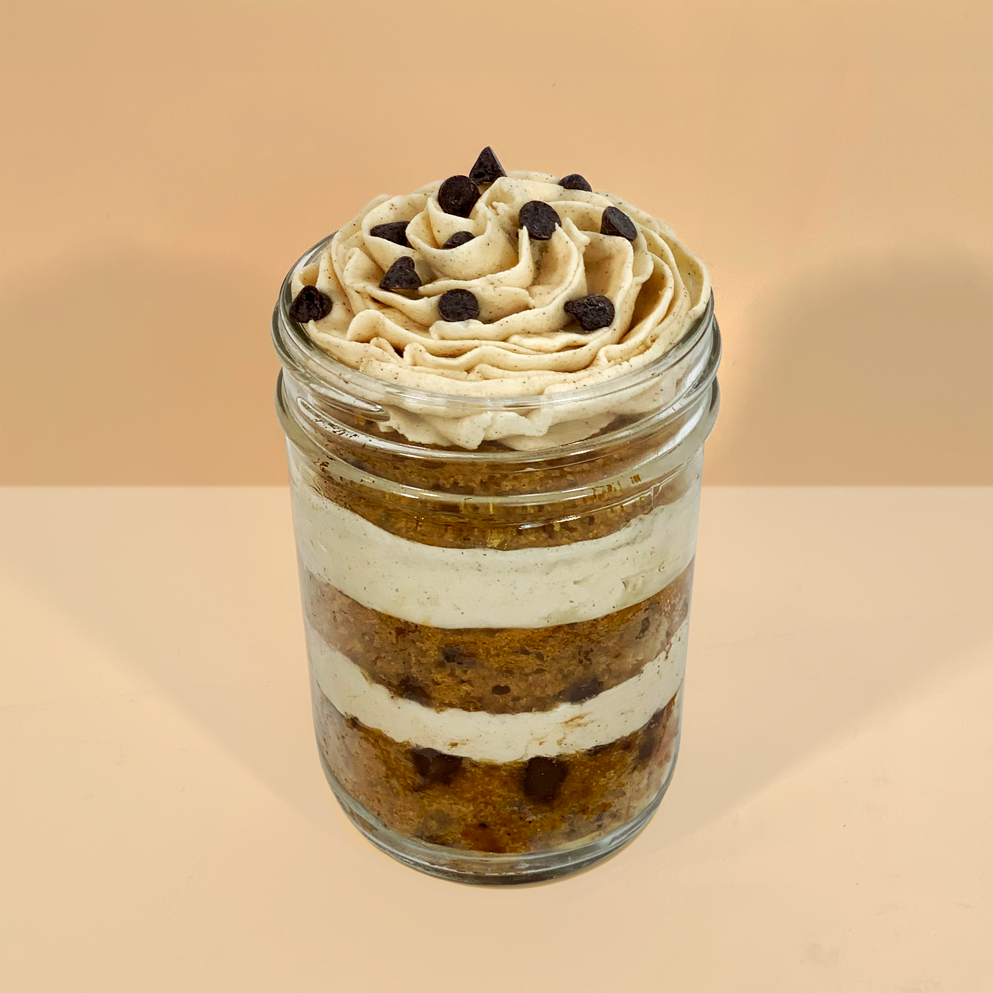 Close-up of a fall kosher cupcake jar with vanilla cake, chocolate buttercream, and fall sprinkles.