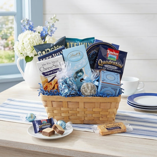 Blue Skies to You gift basket with Lindt LINDOR truffles, Loacker Quadratini wafers and John Wm. Macy's CheeseSticks, styled on a whitewashed table in a bright coastal breakfast nook