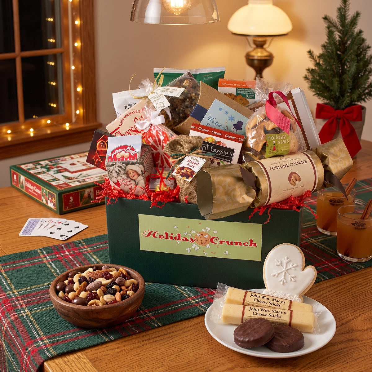 Holiday crunch gift box in green with chocolate covered Oreos, cheese sticks, snack mix, pretzels and a mitten sugar cookie, opened for family game night at Christmas