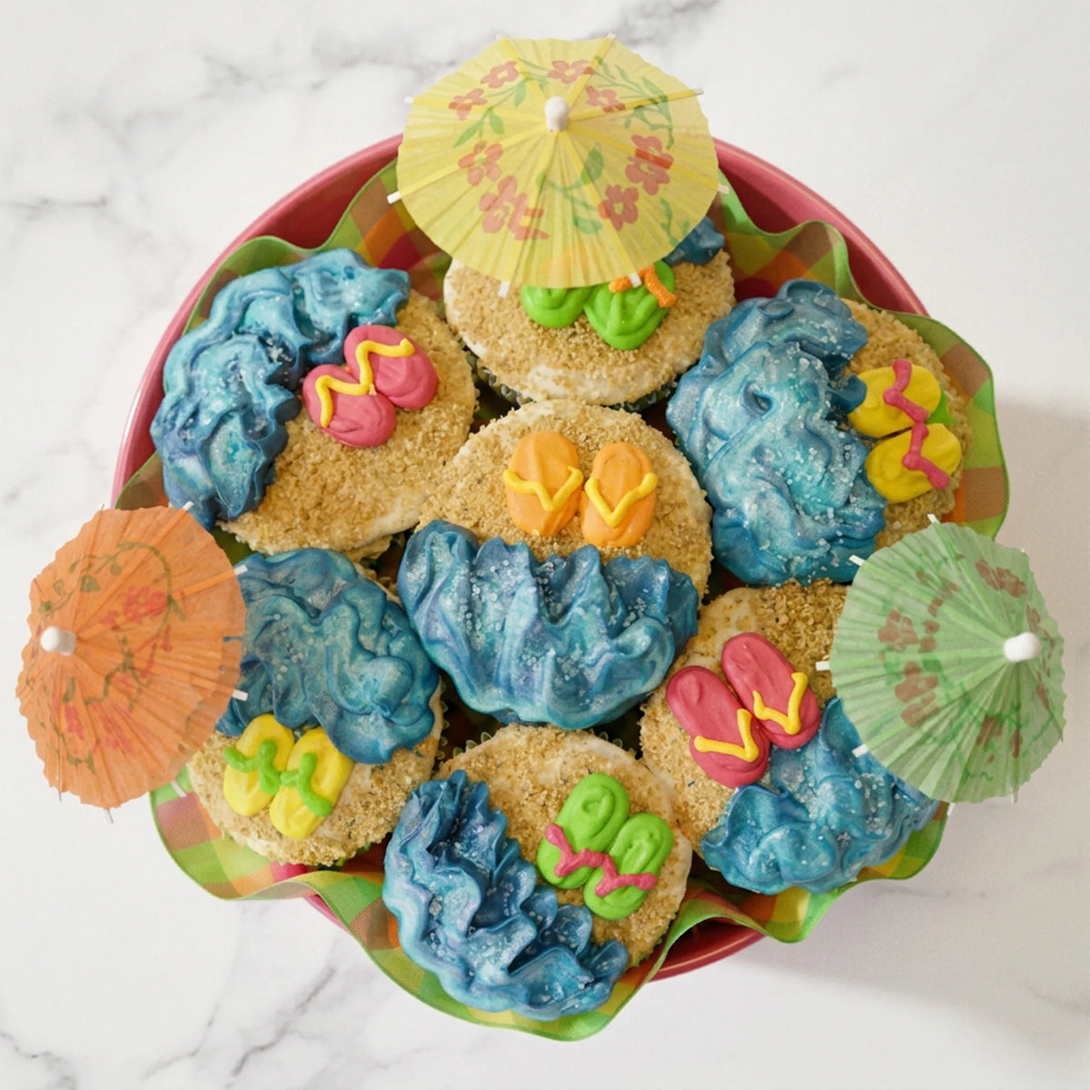 Overhead view of the Beach Cupcake Bouquet showing buttercream waves, graham cracker sand and fondant flip flops, kosher, made in Chestnut Hill MA