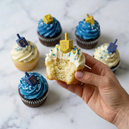 Hanukkah dreidel cupcakes in vanilla and chocolate, one held with a bite showing the vanilla crumb, kosher, made in Chestnut Hill MA