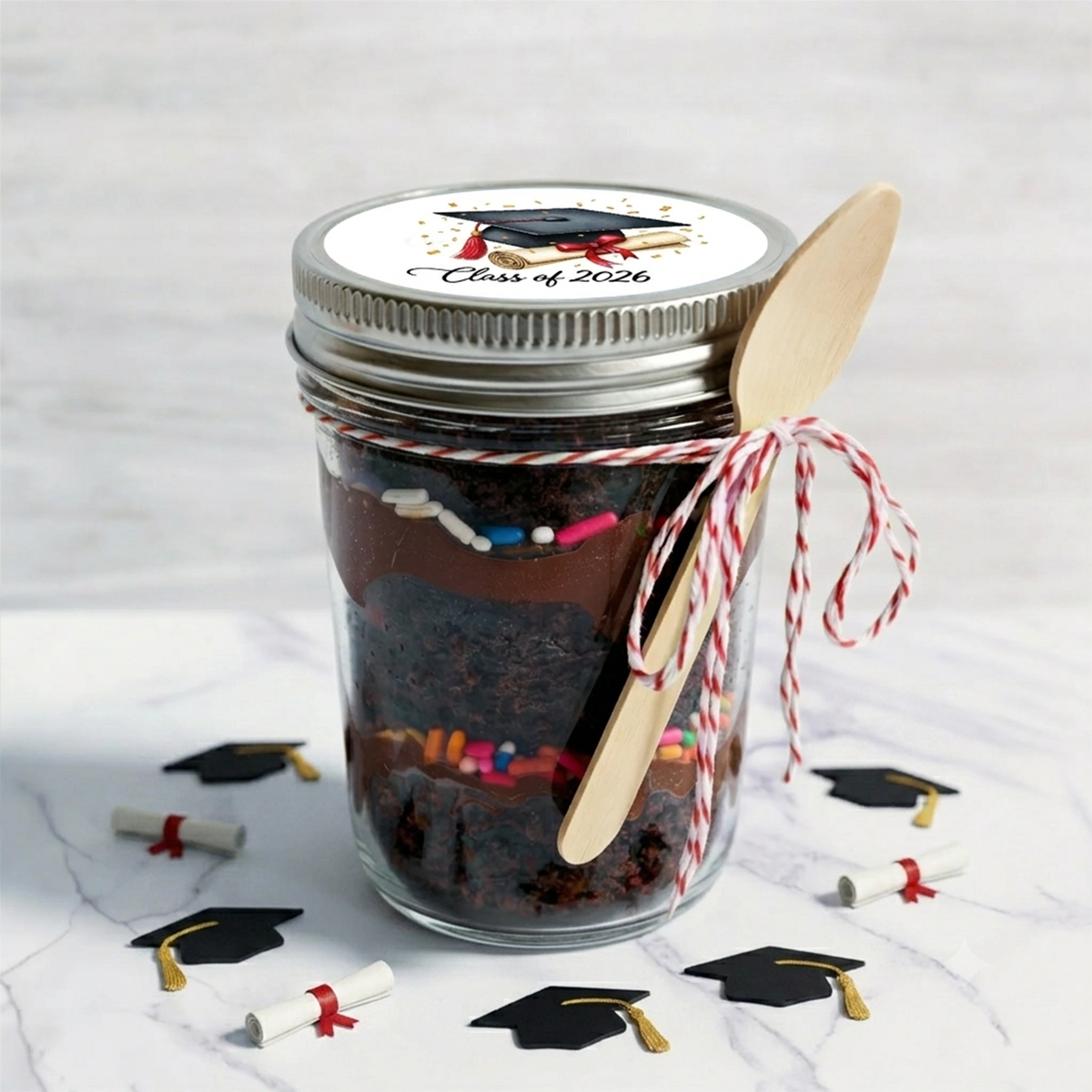 Chocolate graduation cupcake jar with a Class of 2026 lid, a wooden spoon and red and white twine, kosher, made in Chestnut Hill MA