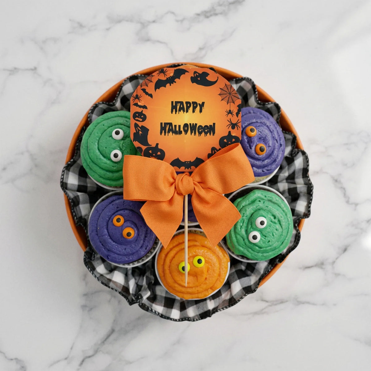 Top view of a Halloween cupcake bouquet with candy eye cupcakes, a gingham collar and an orange bow, kosher, made in Chestnut Hill MA