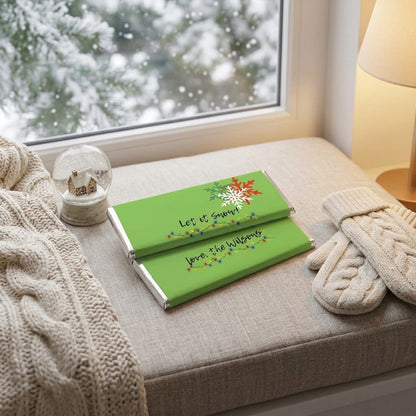 Let it Snow wrapped Hershey's chocolate bars on a cozy window seat with a snow globe, knit mittens, and snow falling outside