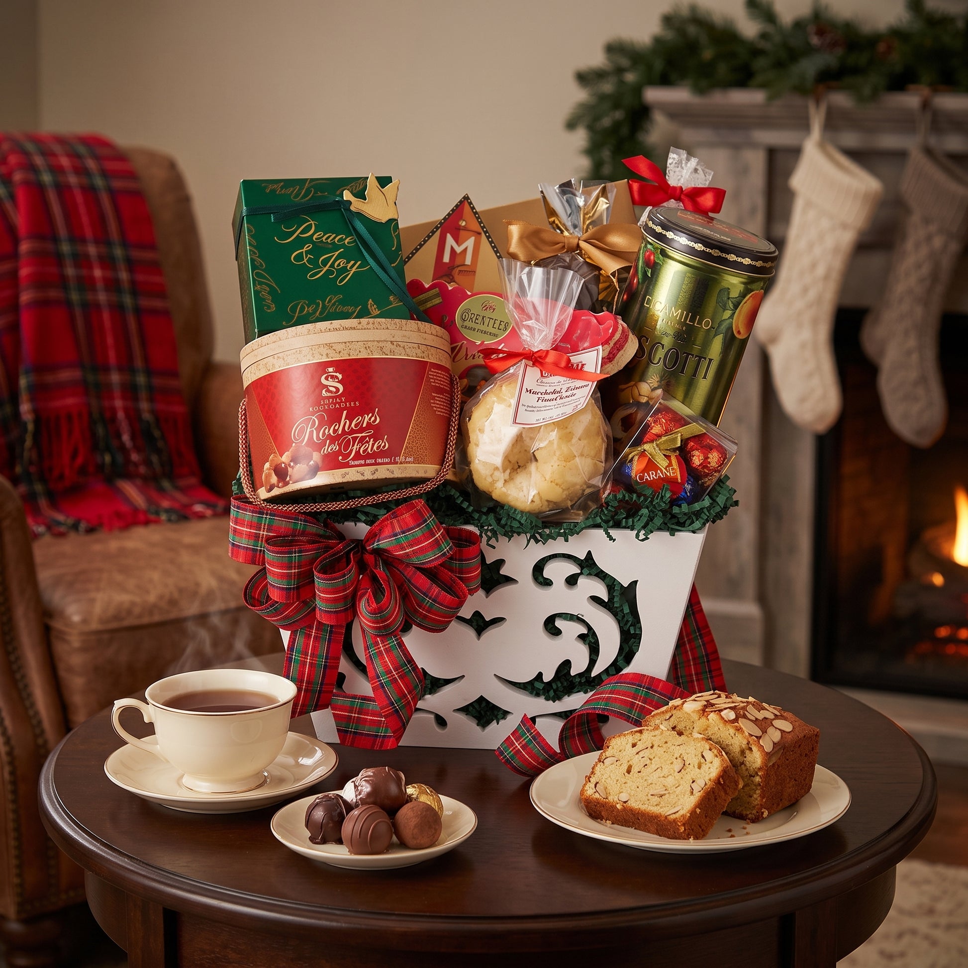 Peace and Joy holiday gift basket in a white keepsake box with tartan bow, chocolate drum and almond pound cake, on a side table beside a Christmas fireplace
