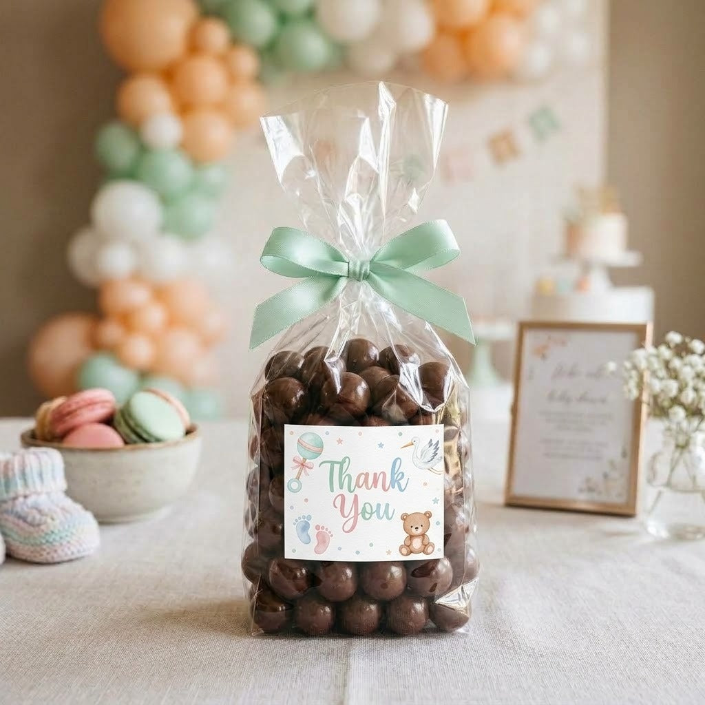 Junior Mints candy bag tied with a mint green ribbon and a printed baby shower Thank You graphic label with a rattle and teddy bear on a pastel baby shower dessert table, kosher, made in Chestnut Hill MA